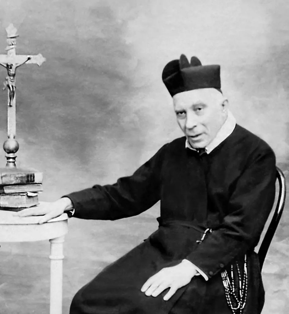 Padre Antonio Maria Losito seduto accanto a un crocifisso